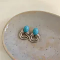 Primo piano di orecchini vintage in turchese con un design geometrico argentato. - Argento-Blu