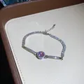 Close-up of sparkling silver bracelet with a pink zircon center and stone-set band - Silver Pink
