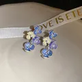 Vista dettagliata di orecchini a lobo a fiore con petali blu-viola e cristalli - Perno in Argento - Argento (HE33658) / Blu scuro