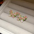 Close-up of butterfly stud earrings with pink, green, and clear zircon stones. - Pink and Green Butterfly Style