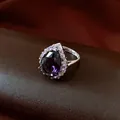 Detailansicht eines eleganten, lila Zirkonia-Rings in Birnenform mit Halo-Fassung - Silber-Lila