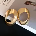 Detailed view of large hollow geometric oval earrings in shiny gold finish - Gold