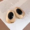 Detailed macro shot of vintage gold oval earrings with black resin inlay on paper - Vintage Oval Style (HE34232) / Gold-Black