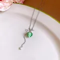Detailed view of an elegant resin grape necklace with white flower and pearl accents - Silver & Green