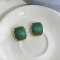 Close-up view of elegant geometric gold earrings featuring vibrant green pave stone inlay - Geometric Rectangular Style (HE33656) / Gold Green