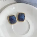 Close-up of elegant gold geometric stud earrings with blue zircon paving. - Geometric Rectangular Style (HE33656) / Gold Blue