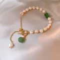 Detail eines Süßwasserperlen-Armbands mit goldenem T-Verschluss und Strasssteinen. - Strass OT Schnalle Perle Stil / Grün-Gold