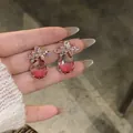 Gros plan d'élégantes boucles d'oreilles en zircon avec des pierres roses en forme de goutte. - 2# Crochet d'oreille-Or-Rose