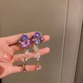 Détail de boucles d'oreilles pendantes élégantes avec roses mauves et strass brillants - Style Gland Rose Violette Française (15#)