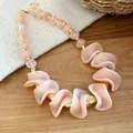 Detailopname van onregelmatige perzik acrylkralen op een retro-stijl kralen halsketting. - Ketting / Roze