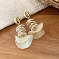 Gedetailleerde weergave van boheemse witte acryl schelpoorringen met gouden oorsteker - Oorknopjes (Met Zilveren Stift) / Licht koffiebruin