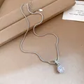 Detailed macro view of a silver necklace featuring a sparkling round zircon pendant. Exquisite. - Silver