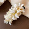 Close-up detail of an elegant white fabric flower hair clip decorated with clear beads - Duckbill Hair Clips / Single Piece / White