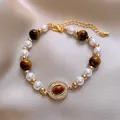 Französisches Armband mit weißen Perlen, Tigerauge-Perlen und goldfarbenen Details. - Gold & Braun (11)