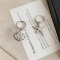 Close-up of asymmetrical silver earrings featuring starfish and seashell with pearls - Hoop Earrings-Silver