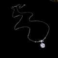 Close-up of sparkling 14K gold plated square zircon pendant on black background - Silver
