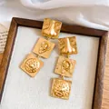 Detailed view of vintage gold earrings featuring embossed nose and ear designs - Facial Features Shape / Gold