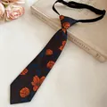 Detailed view of vintage handmade floral embroidered tie necklace on an antique book - Black-Coffee