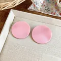 Macro detail view of pink textured round stud earrings in a sweet, trendy Korean style. - Pink