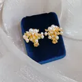 Elegant 18k gold plated firework ear clips featuring white pearls and sparkling CZ stones - Clip-On Earrings / Gold