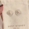 Elegant minimalist hollow flower stud earrings featuring pink pearl on a linen gift pouch - Hollow Spiral Pearl Stud Earrings (HE33830) / Pink