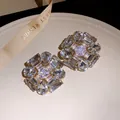 Detailed macro view of silver needle geometric stud earrings with sparkling clear zircon stones - Gold