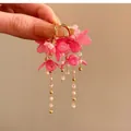Vue détaillée de boucles d'oreilles fleur en résine rose avec longs glands de perles - Style Créole à Gland de Fleur / Plaqué Or Rose