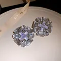 Close-up macro view of sparkling geometric zircon stud earrings with various crystal cuts - Silver
