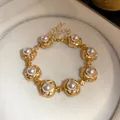 Detailed view of vintage gold-tone pearl bracelet with elegant textured links - Bracelet / Gold+White