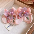 Primo piano di eleganti orecchini a fiore in chiffon rosa con resina viola e perline. - Stile Pendente Fiore in Chiffon / Mix Viola Chiaro e Arancione Chiaro