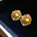 Detailed view of luxury golden pearl earrings with floral zircon accents in a black box - Stud Earrings (925 Silver Pin) / Gold