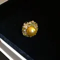 Macro detail of a vintage golden pearl ring with sparkling zirconia flower accents - Ring / Gold