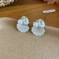 Detailed shot of French style shell flower earrings with clustered pearls and beads - Shell Style / White