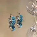 Close-up of blue zircon wheat ear hoop earrings on a reflective surface - Ear Buckle / Silver-Blue
