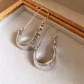 Macro view of minimalist silver U-shaped earrings featuring a unique hammered texture - U-Shaped Hammered Ear Hook / Silver