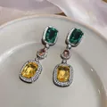 Detailed view of vintage dangle earrings with green, peach, and yellow cubic zirconia stones - Silver Style