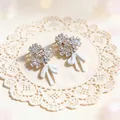 Vista detallada del diseño de flor de strass brillante con colgante de lazo blanco. - Plata-Blanco