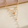 Detailed view of gold multi-layer necklace with pearl beads, shell and flower charms. - Four Layered Style / Gold