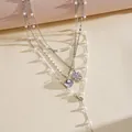 Detailed shot of multilayer silver necklace with pearls, shell and flower charms. - Four Layered Style / Silver