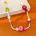Macro view of colorful resin fruit charms and small pearls on a sweet summer style necklace - Choker Necklace / Red Green White