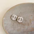 Close-up of hollow oval earrings with zircon and pearls on ceramic plate - 1# Silver Post - Silver (Earrings)