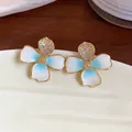 Close-up detail of gradient enamel flower earrings with gold finish and zircon stones - Gold and Blue (Gold Plated) Silver Post