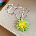 Close-up of vibrant green and yellow flower pendant on a colorful pearl beaded necklace - Green