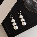 Detailed macro view of silver metallic tiered petal earrings featuring a polished smooth finish - Stud Earrings / Silver