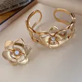 Exquisites vergoldetes Blumen Armband und Ring Set mit Perlen auf elegantem Stoff - Armband Und Ring Set / Gold