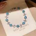 Nahaufnahme eines 18k vergoldeten Armbands mit blauen Zirkonia und Blumengliedern. - Blauer Zirkonia Blumenstil (51#)