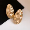 Detailed view of vintage gold oval stud earrings with elegant hammered metal texture - Gold
