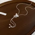Detailed view of a silver Y-shaped necklace featuring a delicate lace bow pendant. - Y-Shaped Bow Style / Silver