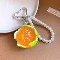 Close-up detail of a realistic resin orange pendant with pearl beads and heart clip - Green Tangerine (AQ410) / Silver Heart Spring Ring / Green Orange