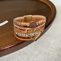 Detailed view of bohemian multi-layer leather bracelet with gold heart charm - Brown